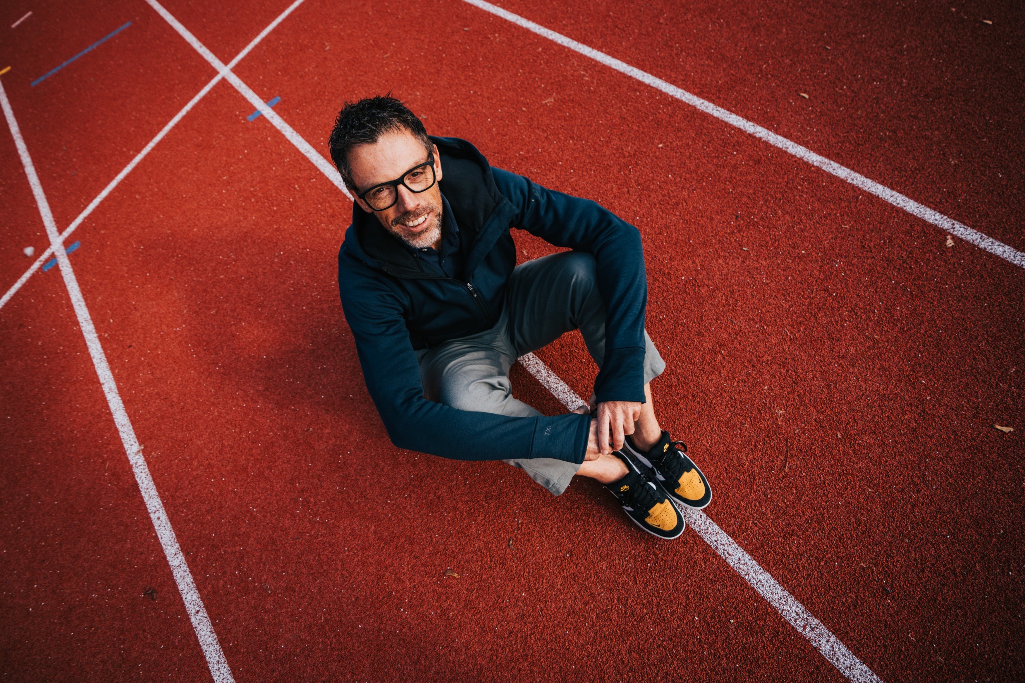 Bas Eefting zit op de atletiekbaan en kijkt omhoog